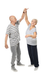 Fototapeta premium Cute elderly couple dancing against white background