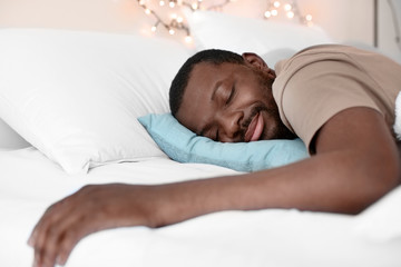 Fototapeta na wymiar African American man sleeping in bed