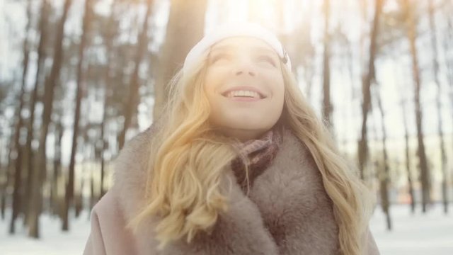  beautiful smiling girl in a coat in a winter forest