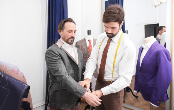 Tailor with client in atelier. Sewing custom made suit