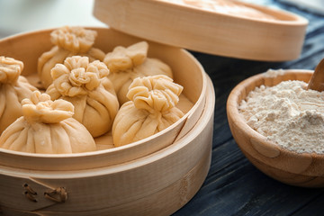 Tasty baozi dumplings in bamboo steamer on table