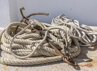 old iron anchor and mooring ropes left on the floor