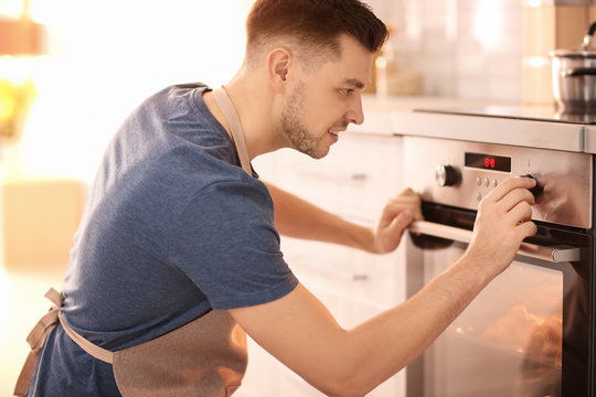 Man adjusting electric oven in kitchen