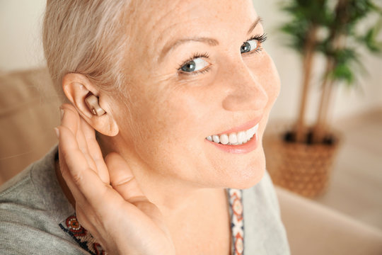 Mature woman with hearing aid, closeup