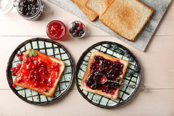 Delicious toasts with sweet jams on wooden table