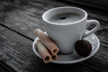 White cup of coffee on a natural old wooden background with biscuits. Selective focus. With copy space