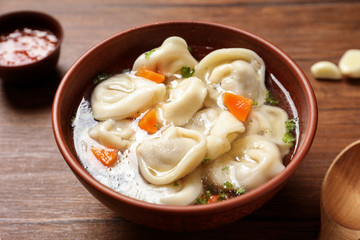 Bowl of delicious soup with dumplings on table