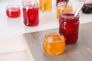 Jars with sweet jams on table