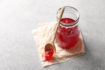 Jar with sweet jam on table