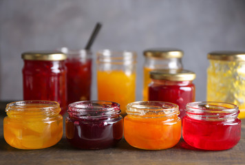 Jars with sweet jams on table