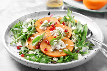 Tasty persimmon with cottage cheese and arugula on plate