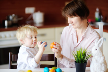 Beautiful woman and her cute son or grandson playing with easter egg on Easter day