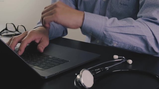 Smart doctor working with new modern laptop computer for online consult in hospital in slow motion

