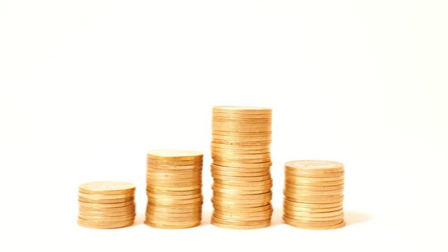 Time lapse of raising and decreasing stacks of coins against white background