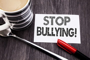 Conceptual hand writing text caption showing Stop Bullying. Business concept for Prevention Problem Bully written on sticky note paper on the wooden wood background. With coffee and marker