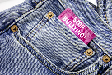 Handwriting Announcement text showing Stop Bullying. Business concept for Prevention Problem Bully Written on condom pack put in the small pocket to pants jeans.