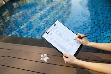 woman holds pen and visa application in UAE Dubai, contributes her data for new trip to foreign...