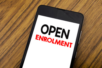Word, writing handwriting Open Enrolment. Business concept for Medicine Doctor Enroll Written on mobile phone cellphone, wooden background with copy space.