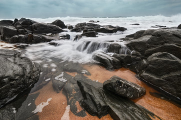 Waves water flowing over rocks at beach. Rocky seascape