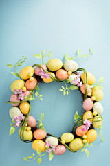 Naklejka na ściany i meble Easter eggs wreath on light blue background
