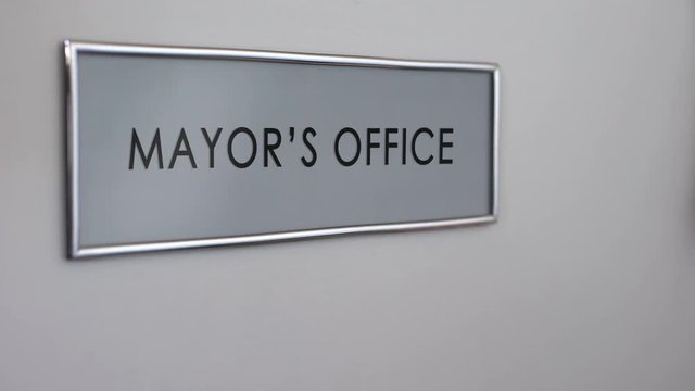 Mayor office door, hand knocking, municipal government official, authority