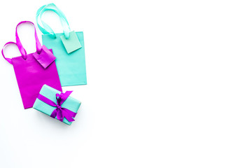 Gift box and colorful paper bag on white background top view copy space
