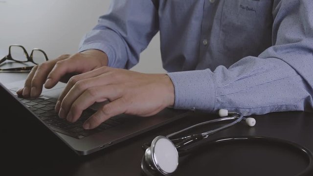 Smart doctor working with new modern laptop computer for online consult in hospital in slow motion
