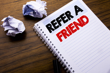 Writing text showing Refer A Friend. Business concept for Referral Marketing written on notebook notepad note paper on the wooden background with folded paper meaning thinking for idea