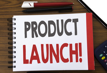 Handwritten text showing Product Launch. Business concept writing for New Products Start Written on notepad note paper, wooden background in office view with pencil marker calculator