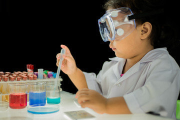 Fototapeta premium Asian little girl working with beaker and test analysis for chemistry in Laboratory room on a black background.