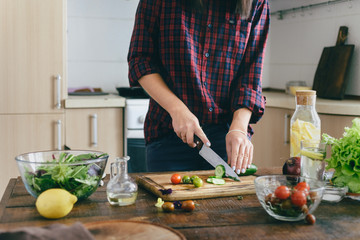 Healthy food. Young woman cooking summer salad at home in the kitchen