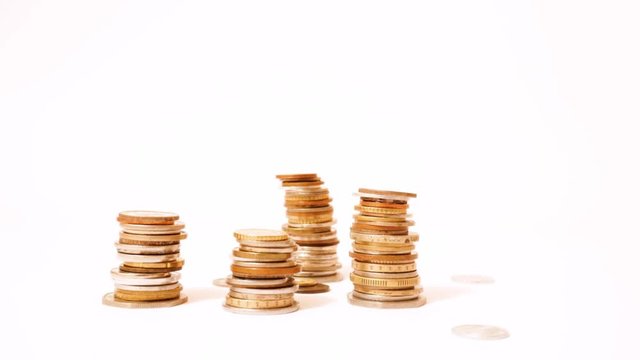 Time lapse of raising and decreasing stacks of coins against white background