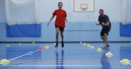 4K Sports teacher coaching young boy, running laps & working hard in school gym