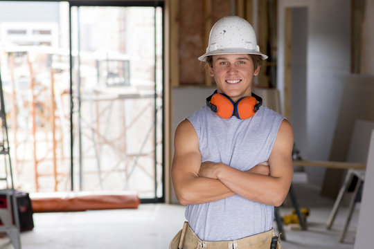 portrait of young attractive builder man on his 20s posing happy confident and proud at construction site wearing protection helmet
