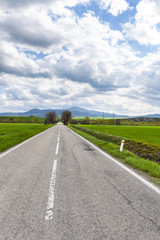 Fototapeta premium Asphalt road between meadow in Italy