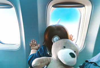 Little toddler boy looking out an airplane window while flying © Tierney
