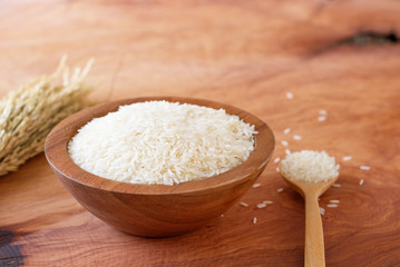 White rice in bowl on wooden background.