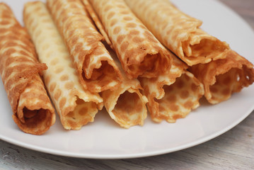 Golden Waffle Tobes or Rolls. Homemade Dessert. White Plate. top view. Toned.