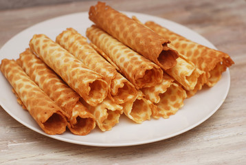 Golden Waffle Tobes or Rolls. Homemade Dessert. White Plate. top view. Toned.