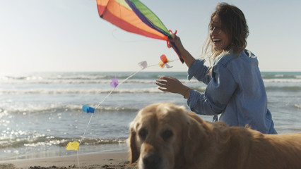 Woman holding kite at beach on autumn day