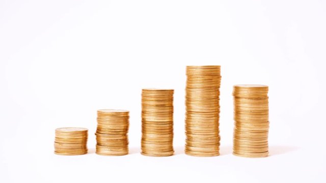Time lapse of raising and decreasing stacks of coins against white background