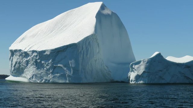 Immense ice berg floating off the coast in a cold sea