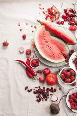 Red fruit and vegetable composition on linen fabric. Summer natural beauty concept with copy space. Vertical composition