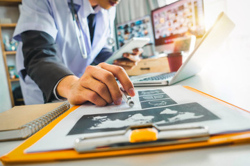 Medical technology concept. Doctor working with smart phone and stethoscope and digital tablet computer in modern office at hospital in morning light
