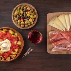 Tapas and wine. Patatas bravas, olives, jamon, cheese, square photo