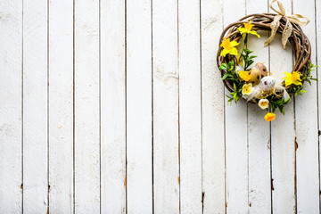 Easter background with spring easter eggs and flowers, wreath on door