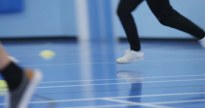 4k, School basketball team playing a game indoors. Slow motion.