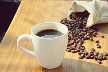 Morning cup of coffee with coffee bean background on wooden table