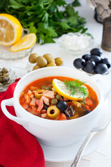 Traditional Russian soup Solyanka in a white serving cup, selective focus
