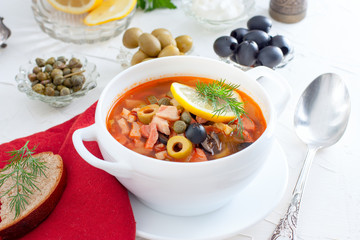 Traditional Russian soup Solyanka in a white serving cup, selective focus